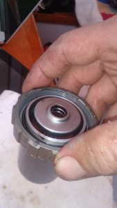 The primary filter sits in a cup with a O-ring to form a seal, and a notched retaining ring to attach it to the mount.